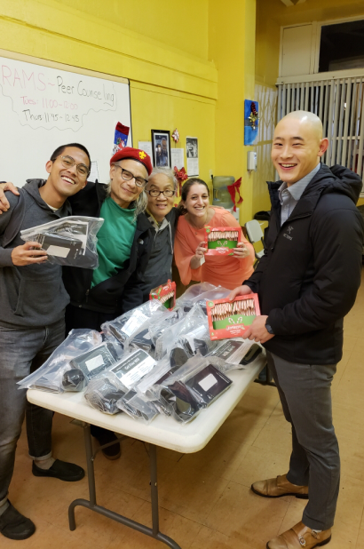 Five volunteer members surrounding a table of holiday care packages.